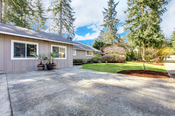 Серый коричневый дом с большой проезжей частью
.