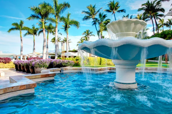 Luxury water fountain in tropial resort with palm trees. — Stock Photo, Image