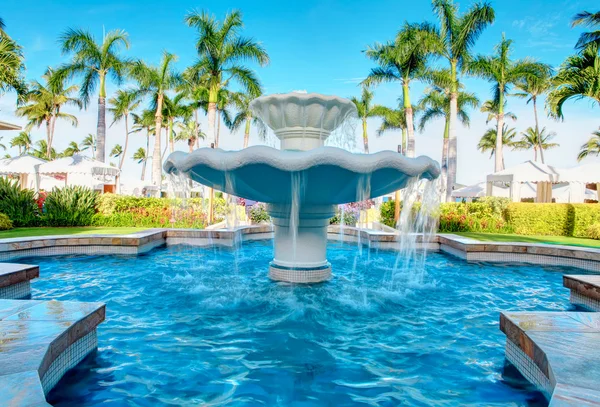 Luxury water fountain in tropial resort with palm trees. — Stock Photo, Image