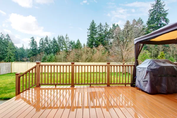 Backyard with wet deck, grill and fence. — Stock Photo, Image