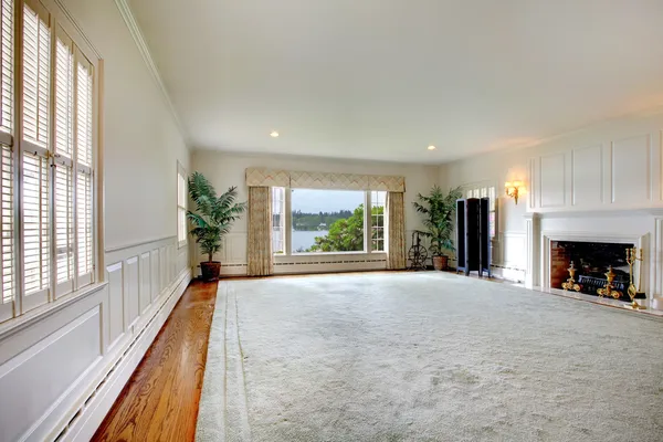 Large empty living room with fireplace and lake view. — Stock Photo, Image