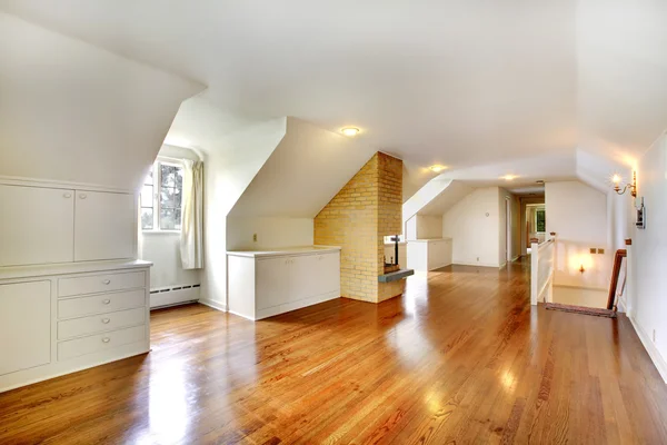 Large long attic room with fireplace. Empty with golden hardwood. — Stock Photo, Image