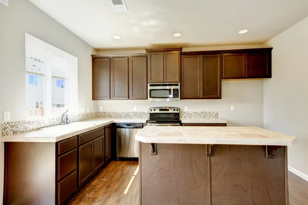 Koyu kahverengi dolapları ile yeni ev mutfak iç. — Stok fotoğraf