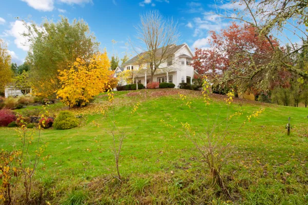 White horse farm American house during fall with green grass. — Stock Photo, Image