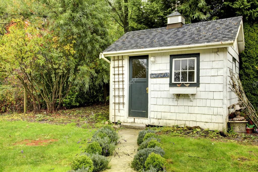 Small White Shed With Green Door And Window Stock Photo