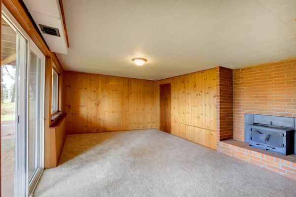 Sala de estar vacía con paredes de madera y chimenea de hierro fundido —  Fotos de Stock