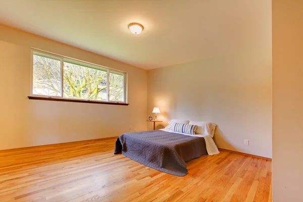 Chambre spacieuse avec des murs aux tons clairs et parquet — Photo