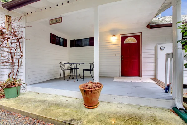 Nice porch with a red door and table set — Stock Photo, Image