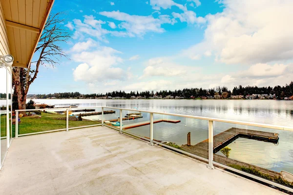 Large back deck overlooking wonderful lake and wooden dock — Stock Photo, Image