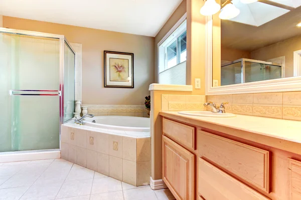 Casa de banho refrescante com armários de madeira clara, chuveiro de vidro e b — Fotografia de Stock