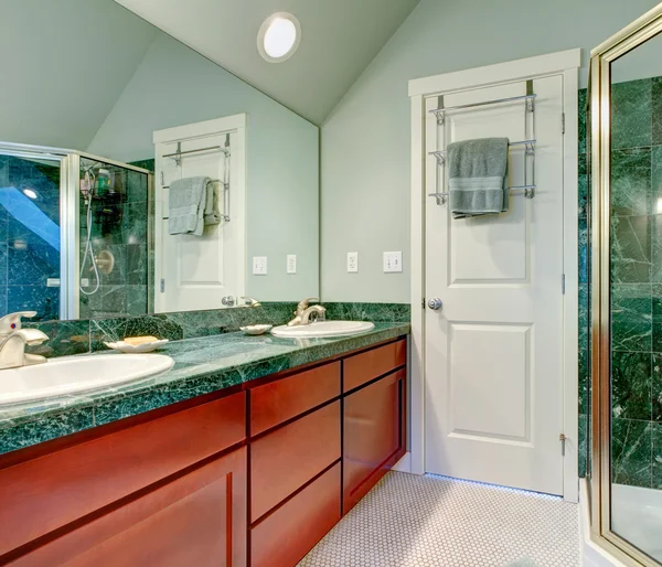 Erfrischendes hellgrünes Badezimmer mit hellen braunen Schränken — Stockfoto