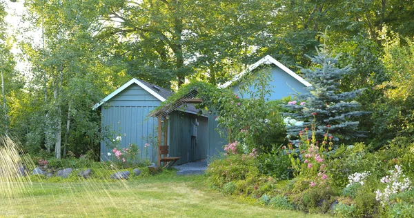 Blühender Bauernhof mit Schuppen und Gartenhaus — Stockfoto