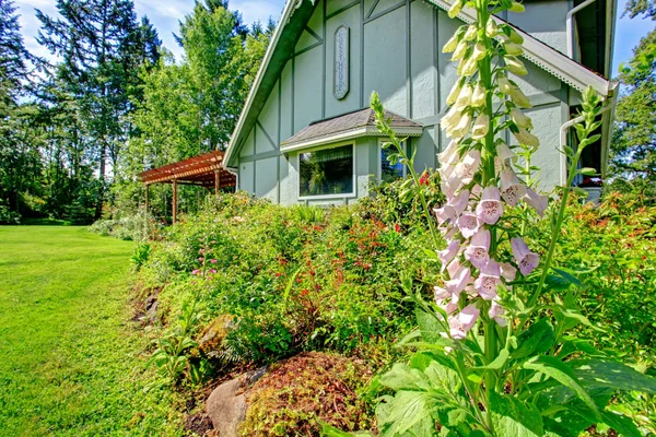 Großes Bauernhaus mit schönem Blumenbeet — Stockfoto