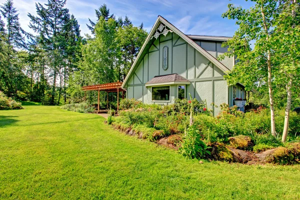 Großes Bauernhaus mit schönem Blumenbeet — Stockfoto