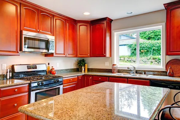 Bright kitchen room with cherry wood storage combination — Stock Photo, Image