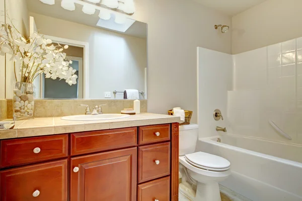 Beautiful bright bathroom with cherry wood cabinets — Stock Photo, Image