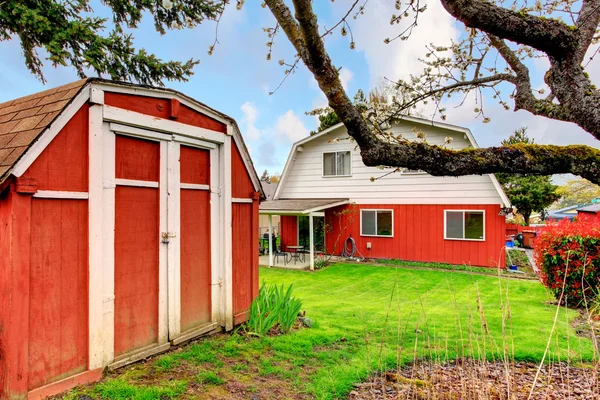 Bakgård med grön gräsmatta och röda Boden — Stockfoto