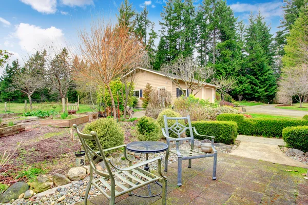 Jardín de primavera con sillas antiguas y mesa — Foto de Stock