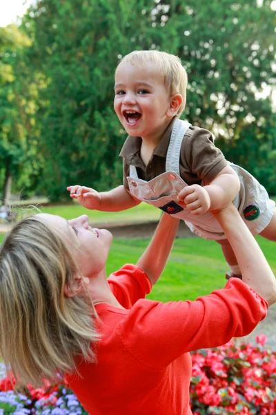 Happy Baby boy and mother are playing in the park during sunset. — Stock Photo, Image