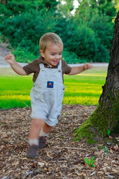 Happy Baby boy está jugando en el parque al atardecer. Running aro —  Fotos de Stock