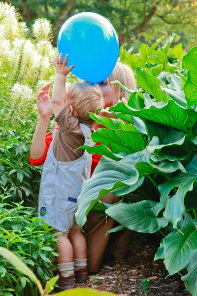 Gelukkig babyjongen en moeder spelen in het park tijdens zonsondergang. — Stockfoto