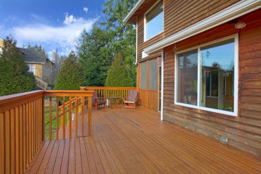 Back of the house with a wooden deck clipart
