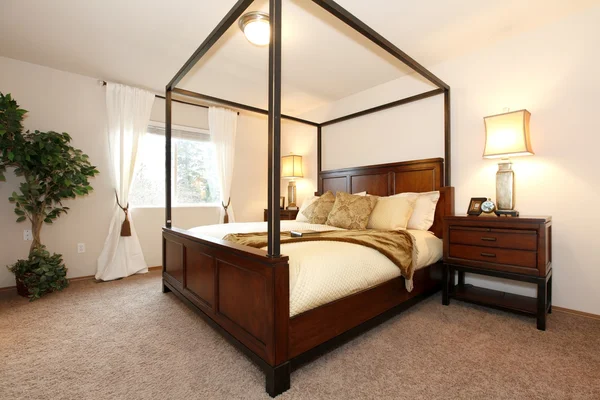 Warm beautiful bedroom with a high posts bed — Stock Photo, Image