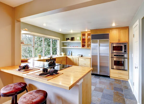 Kitchen with maple cabinets and steel appliances — Stock Photo, Image