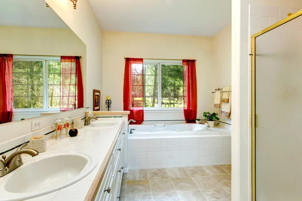 Acogedor baño de marfil con una ventana francesa y cortinas rojas —  Fotos de Stock