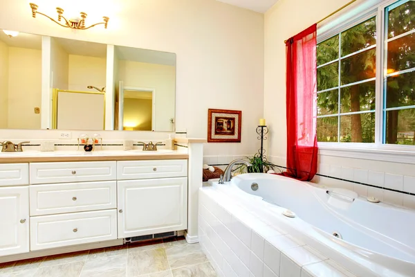 Acogedor baño de marfil con una ventana francesa y cortinas rojas —  Fotos de Stock