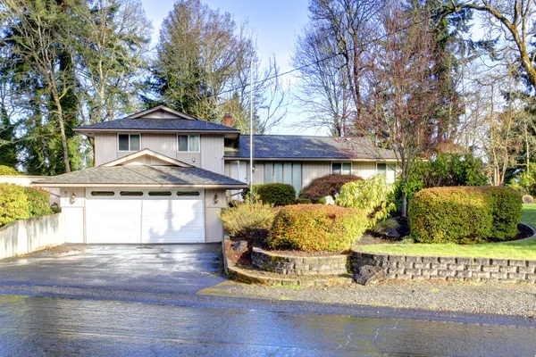 Casa sul lato con grande garage. Vista della strada bagnata — Foto Stock