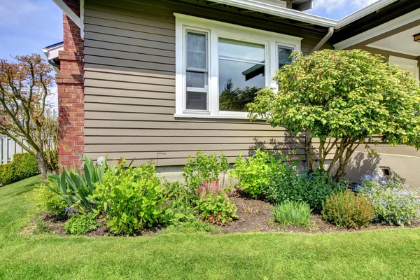 View of the house side wall with window and flower bed — Stock Photo, Image