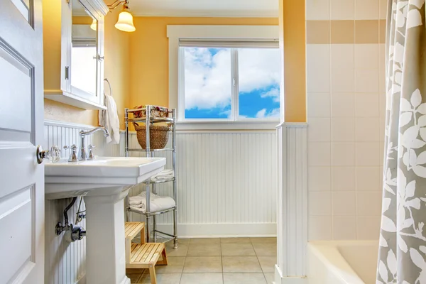 Gele en witte badkamer met een venster — Stockfoto