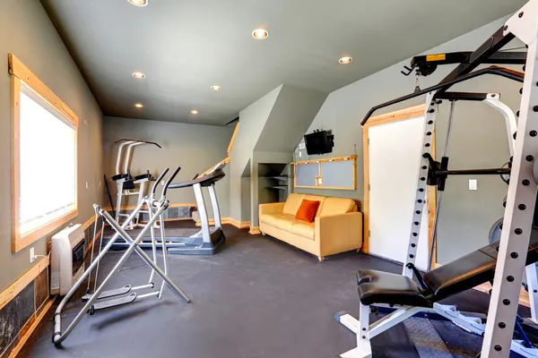 Home gym with yellow couch and TV — Stock Photo, Image