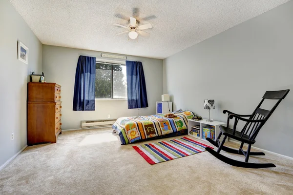 Dormitorio gris con cama colorida y alfombra — Foto de Stock