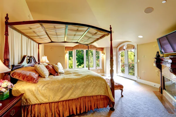 Luxury house interior. Beautiful bed with high posts — Stock Photo, Image