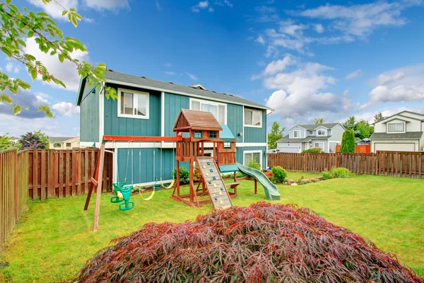 Fenced backyard with playground for kids — Stock Photo, Image