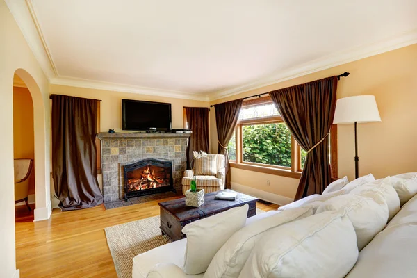 Woonkamer met bruin zitbank, fauteuils en tv gordijn geopend ... Gordijnen living rooms woonkamer