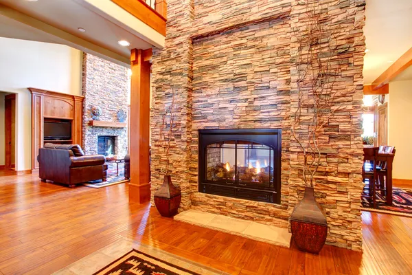 Luxury house interior. Stone wall with fireplace — Stock Photo, Image