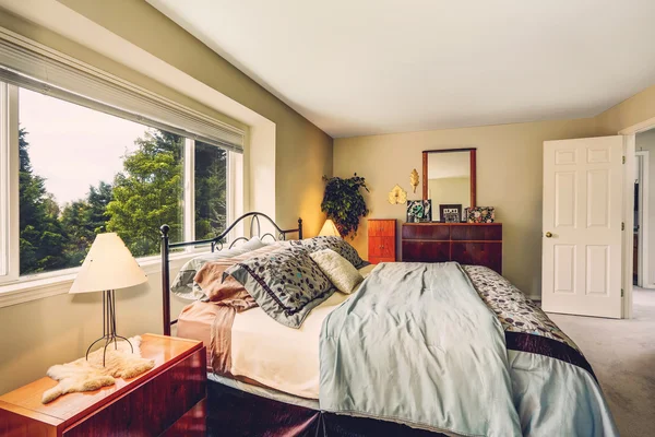 Interior del dormitorio con cama de marco de hierro y armario de tocador — Foto de Stock