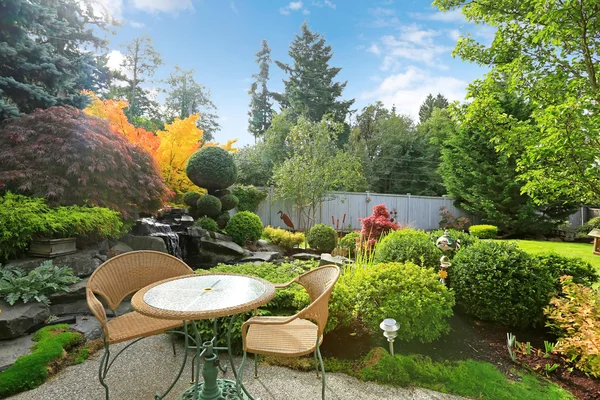 Domácí Tropická zahrada s proutěný stůl set — Stock fotografie