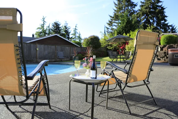 Podwórko z basenem, wina i krzesła. — Zdjęcie stockowe