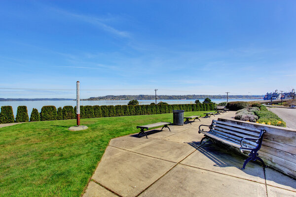 Scenic walkway with wooden benches and bay view