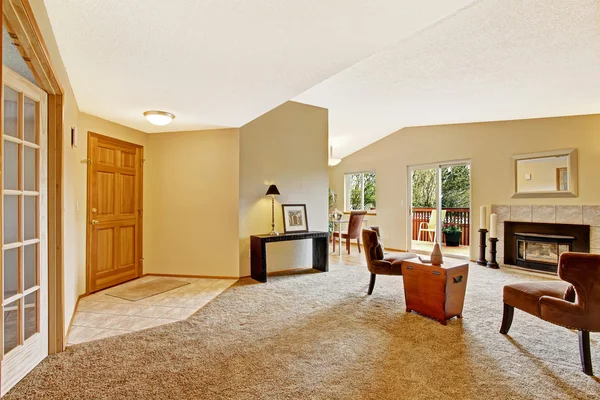 Empty living room in soft ivory with fireplace and walkout deck — Stock Photo, Image