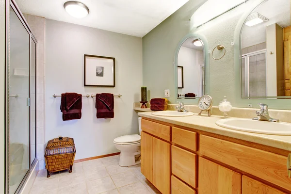 Bright bathroom interior with honey vanity cabinet — Stock Photo, Image