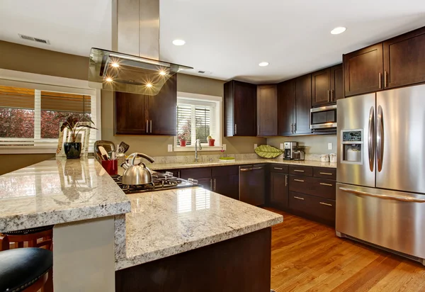 Donkere bruine keuken kamer met stalen toestellen — Stockfoto