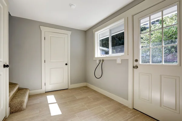 Пустой коридор с кафельным полом и входной дверью — стоковое фото