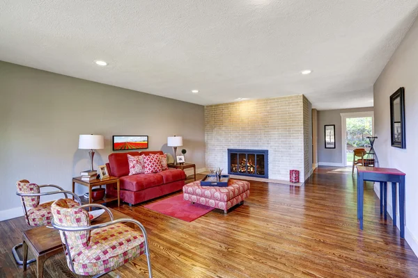 Современный интерьер гостиной с красным диваном и камином — стоковое фото