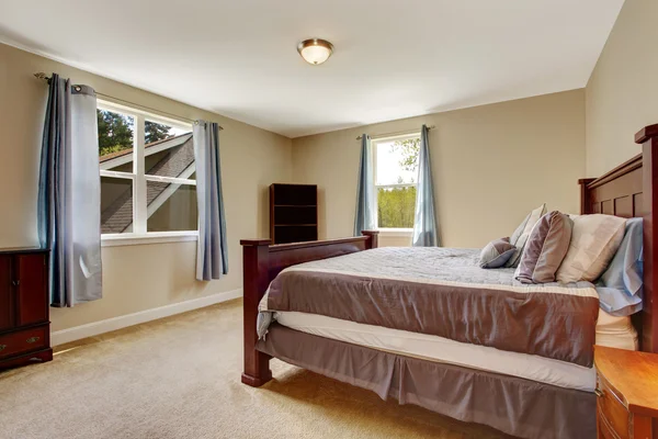 Weiches elfenbeinfarbenes Schlafzimmer mit großem weinroten Bett — Stockfoto