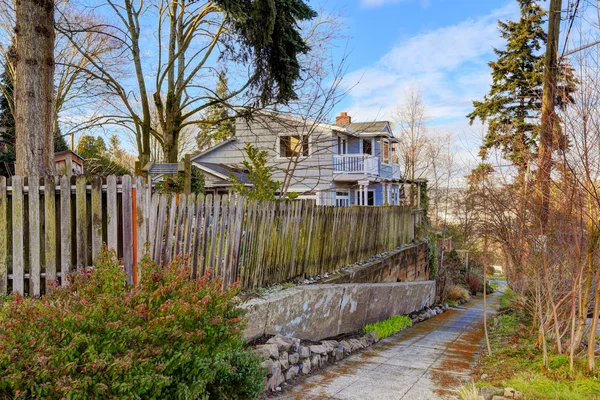 Hausaußenseite. Blick auf alten Zaun mit Gehweg — Stockfoto